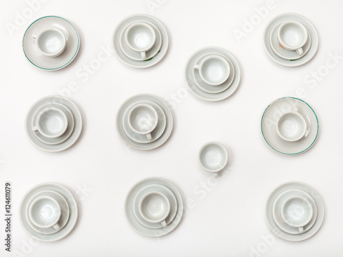 top view of many white cups and saucers on white