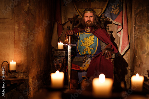 Fotografia, Obraz Medieval king on throne in ancient castle interior.