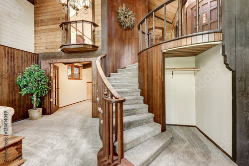 Wooden house interior with circular staircase and carpet floor