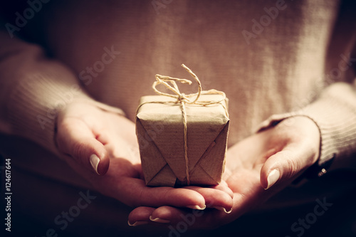Giving a gift, handmade present wrapped in paper photo