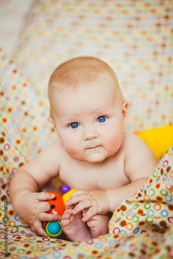 Boy covers toys with his tiny arms Boy covers toys with his tiny arms