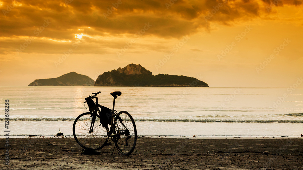 silhouette of a bike standing by the sea