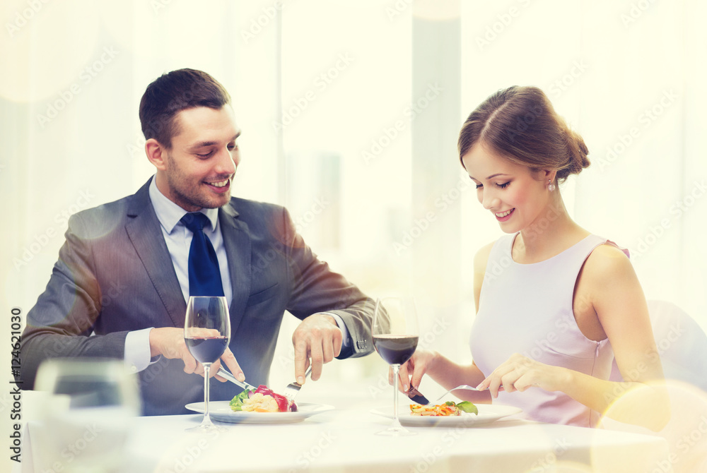 smiling couple eating main course at restaurant smiling couple eating main course at restaurant