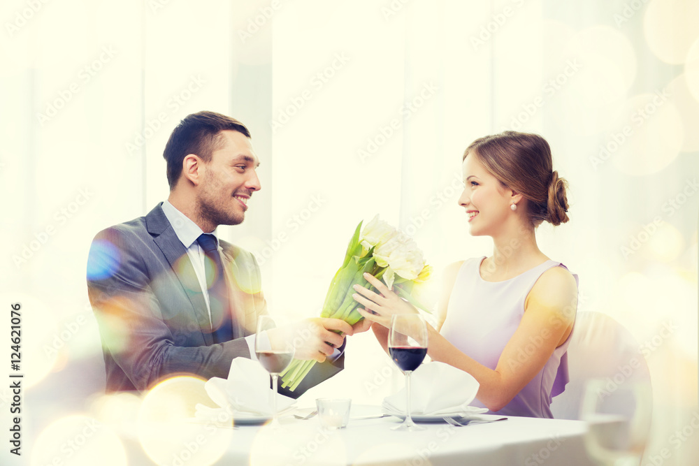 smiling man giving flower bouquet at restaurant smiling man giving flower bouquet at restaurant