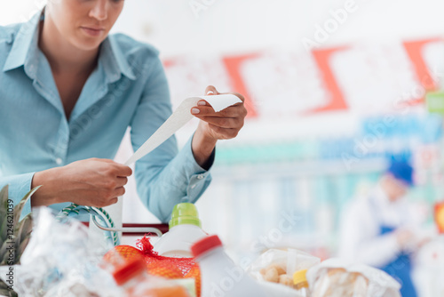 Woman checking a long receipt photo