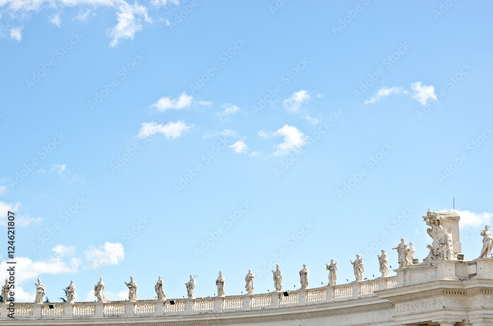 Statues on the roof of  St. Peter's Basilica against the blue sky.