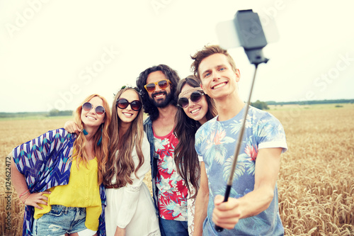 hippie friends with smartphone on selfie stick