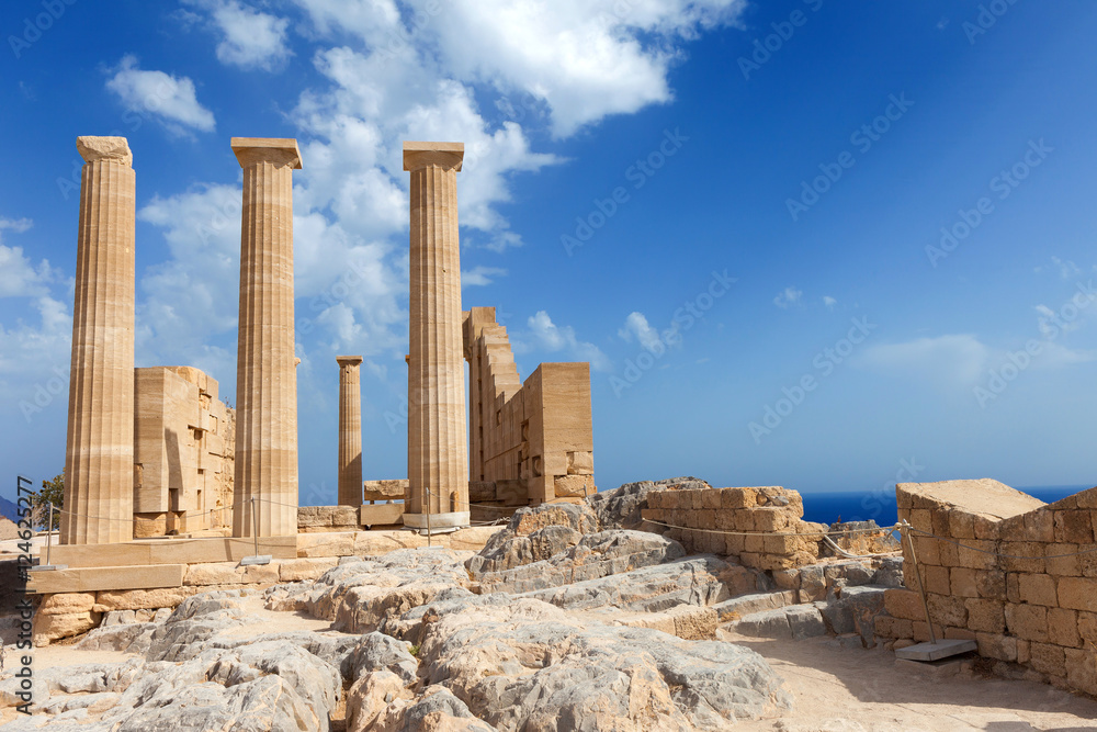 Ancient Greek pillars at the Rhodes  acropolis with blue cloudy sky in the background