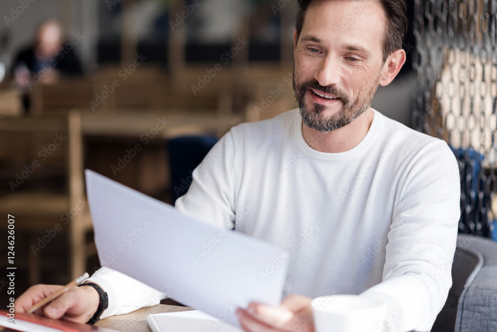 Fototapeta premium Smiling bearded man holding paper