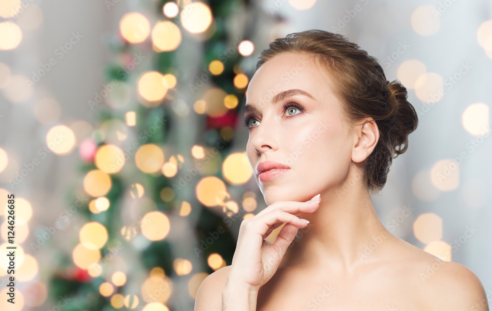 Naklejka premium beautiful woman face over christmas lights