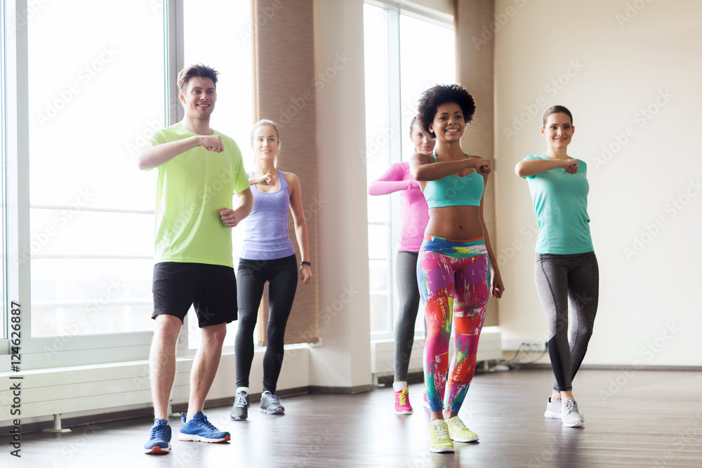 Fototapeta premium group of smiling people dancing in gym or studio