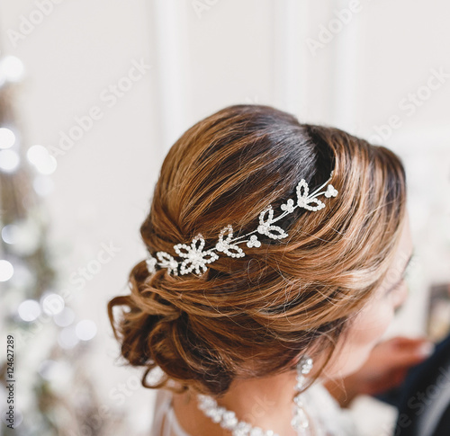 Portrait of attractive young woman with beautiful hairstyle and stylish hair accessory, rear close-up view