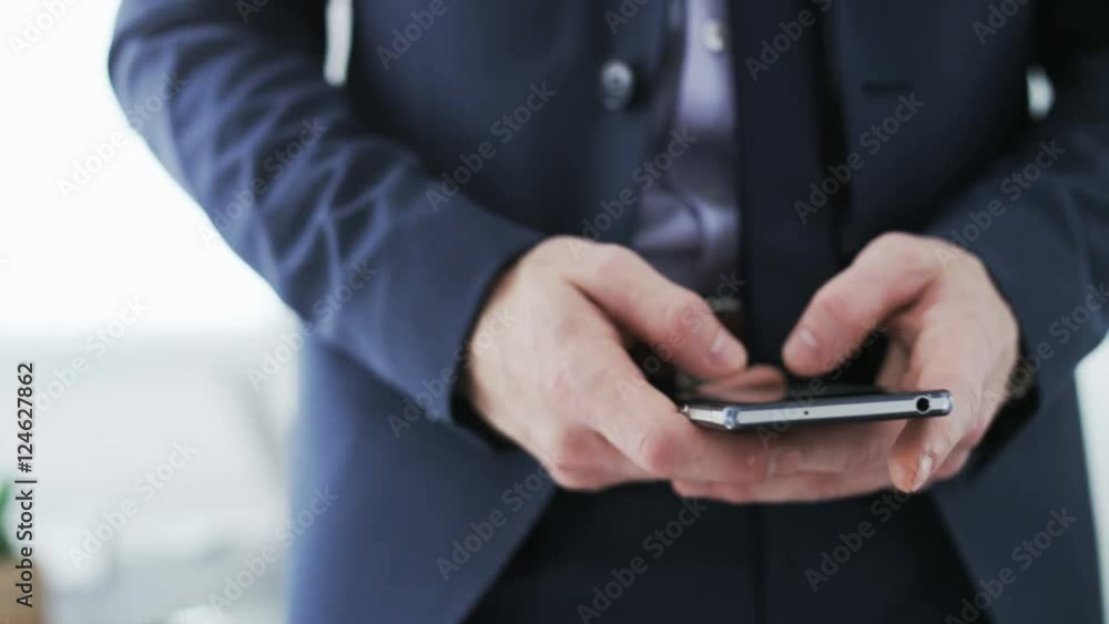 Businessman writing a text message on his mobile Businessman writing a text message on his mobile