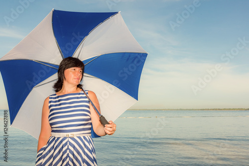 brunette woman with a beach umbrella