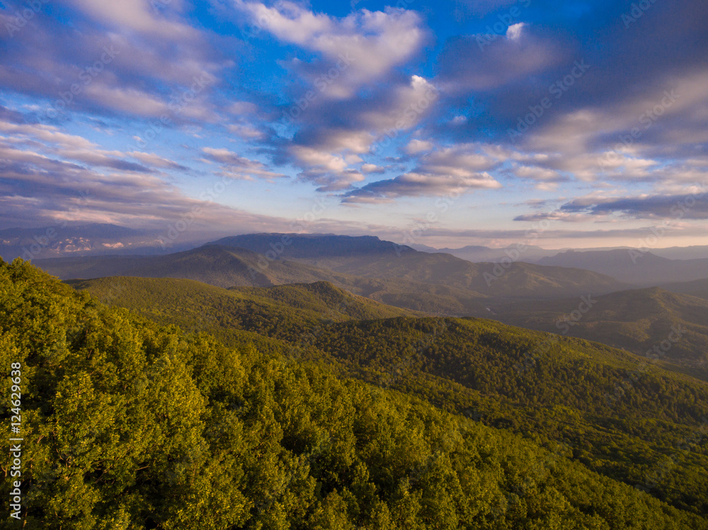 Naklejka premium Mountain forest and cloudy sky in the evening.