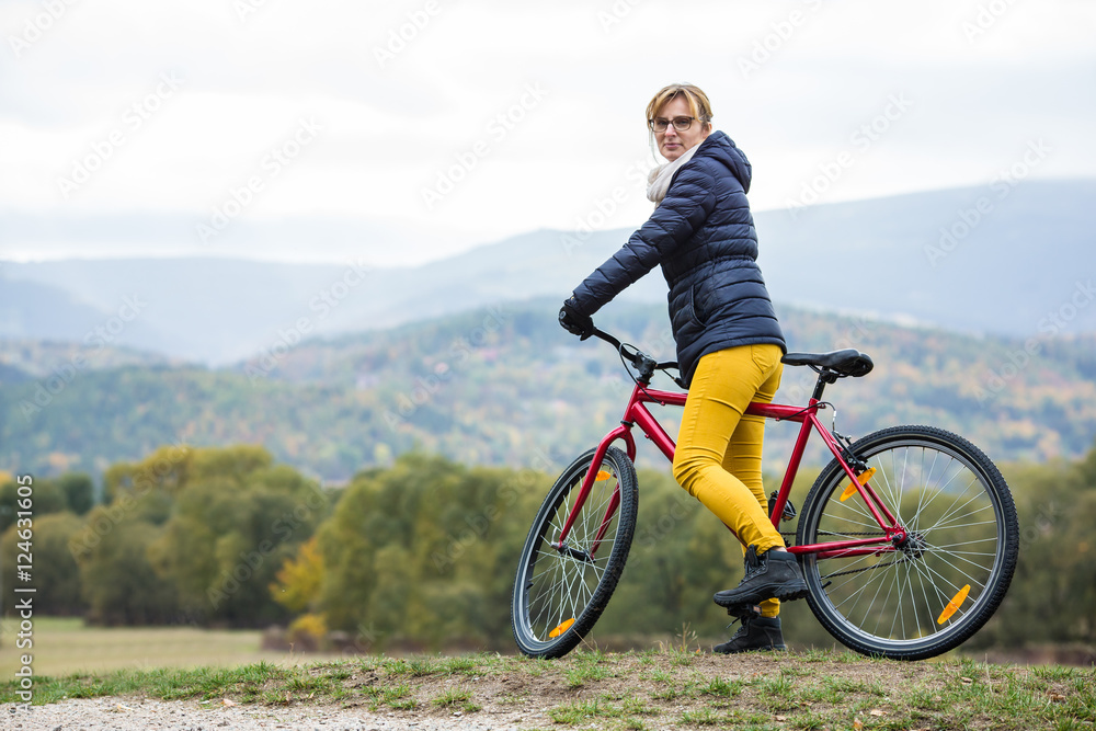 Urban biking - woman riding bike in city park  - obrazy, fototapety, plakaty 