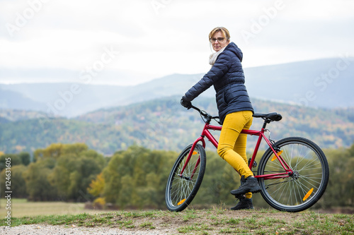 Urban biking - woman riding bike in city park 