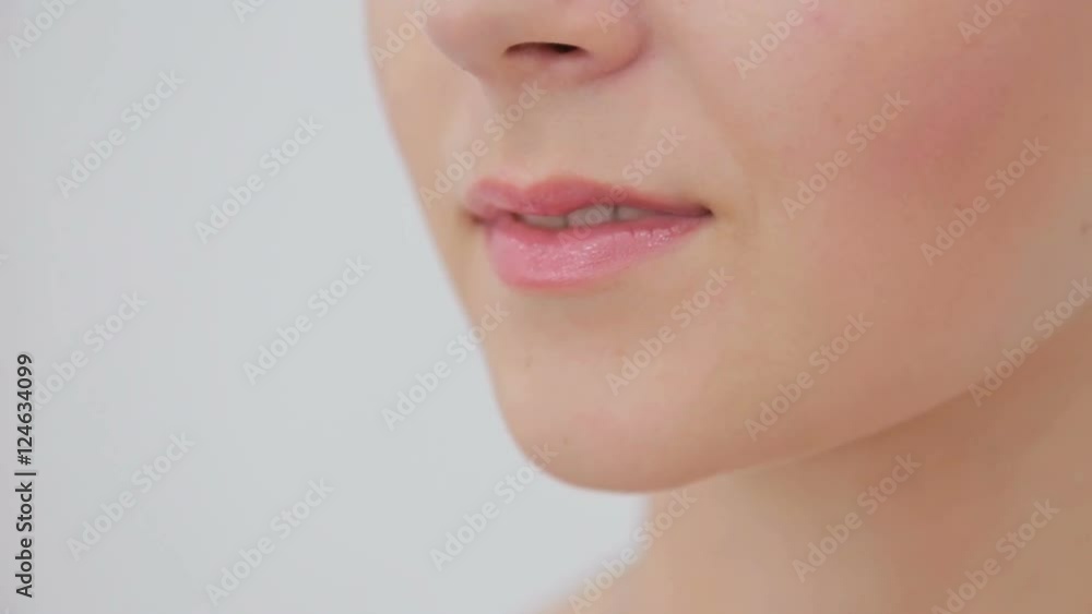 Close up of young woman's lips. White background. Beauty, fashion and make up concept Close up of young woman's lips. White background. Beauty, fashion and make up concept