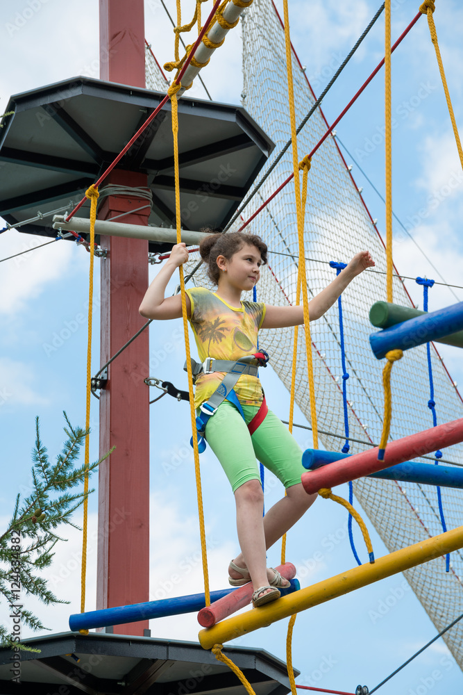 girl in a special gear on a obstacle course passes obstacles