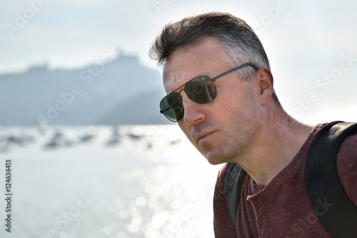 Handsome man over sea view. Outdoor male portrait. Trip, vacatio