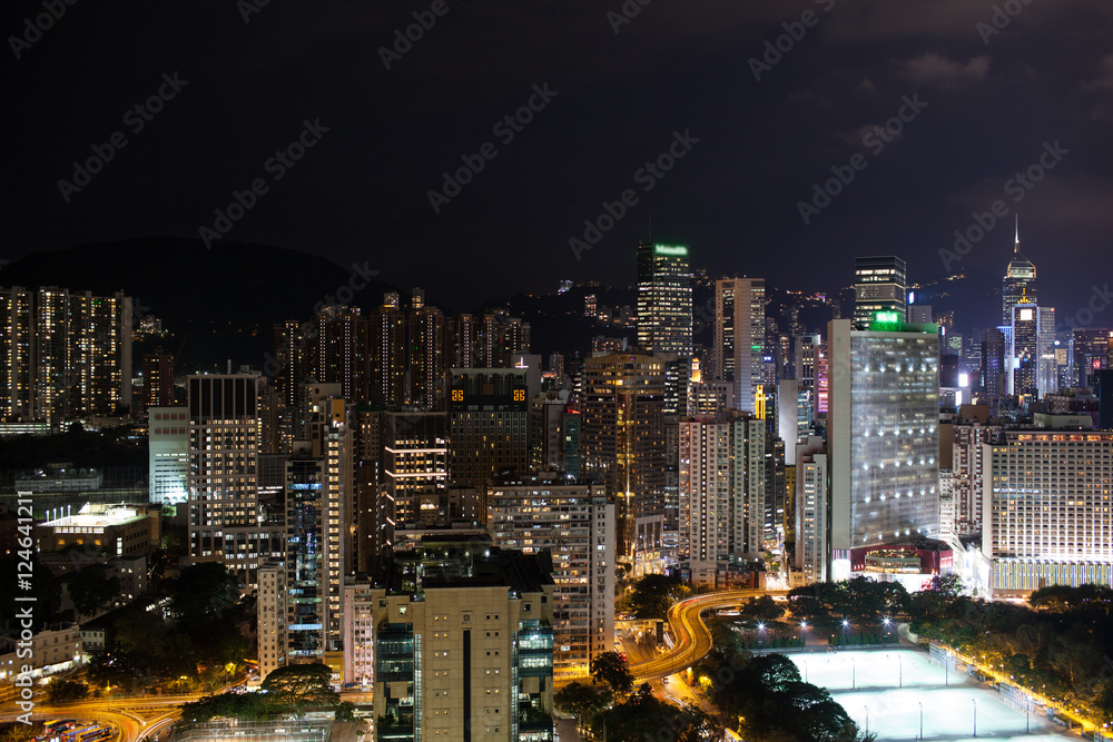 Obraz premium Night panorama of Hong Kong. City with illuminated high-rise buildings, roads and football fields