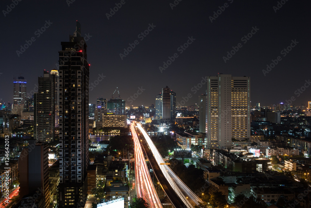 Fototapeta premium Night cityscape of Bangkok, Thailand capital. View to the illuminated buildings and busy motorway