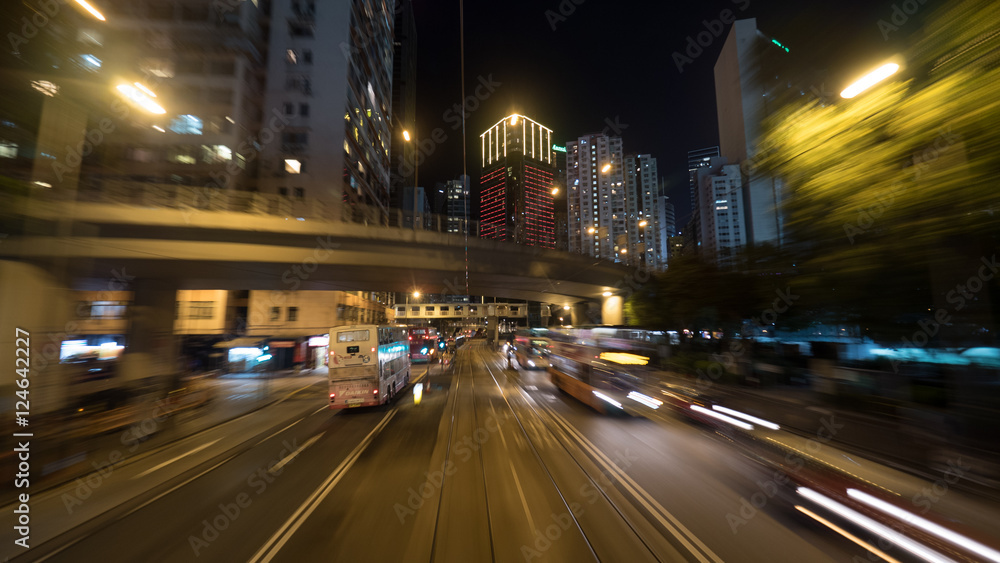 Night Hong Kong view with high-rise buildings, road intersection and transport driving on the highway with rails. Shot in motion Night Hong Kong view with high-rise buildings, road intersection and transport driving on the highway with rails. Shot in motion