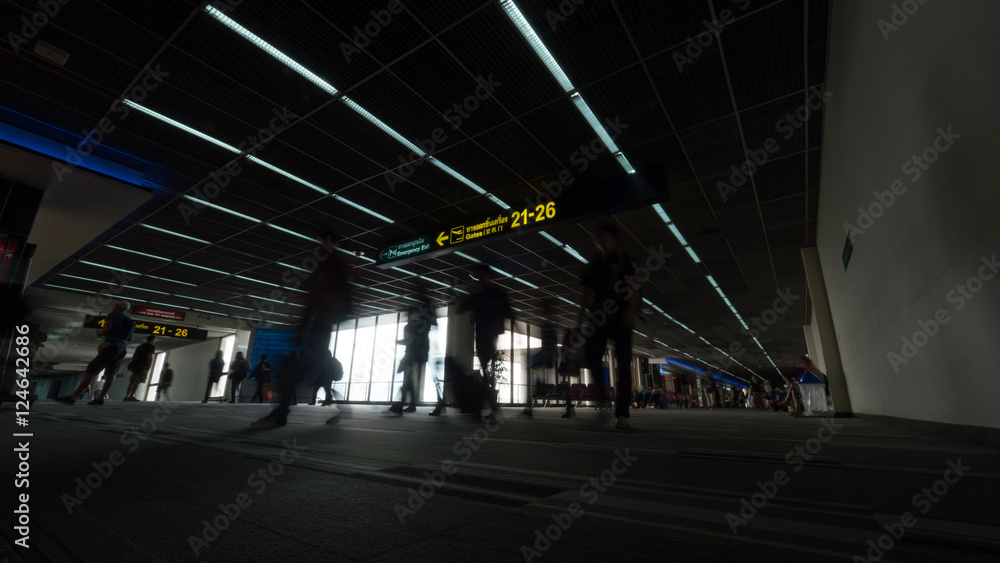 Low angle shot of people walking in airport terminal with Gate pointers and waiting area. Bangkok, Thailand