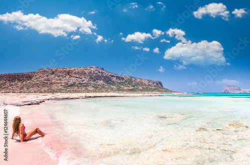 Balos lagoon on Crete island, Greece. A girl on a beach with pink sand.