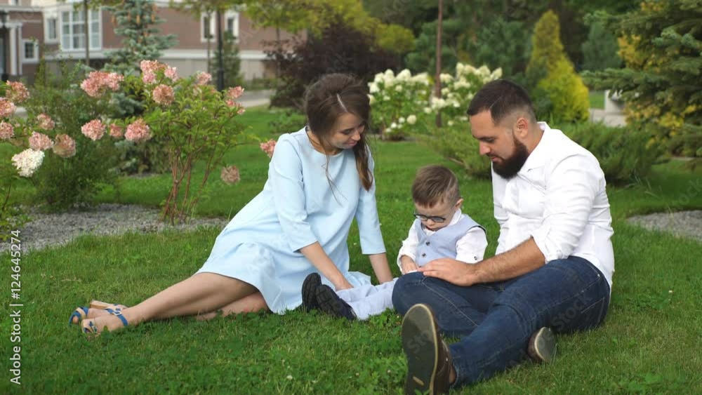 happy family sitting on the grass in the Park happy family sitting on the grass in the Park