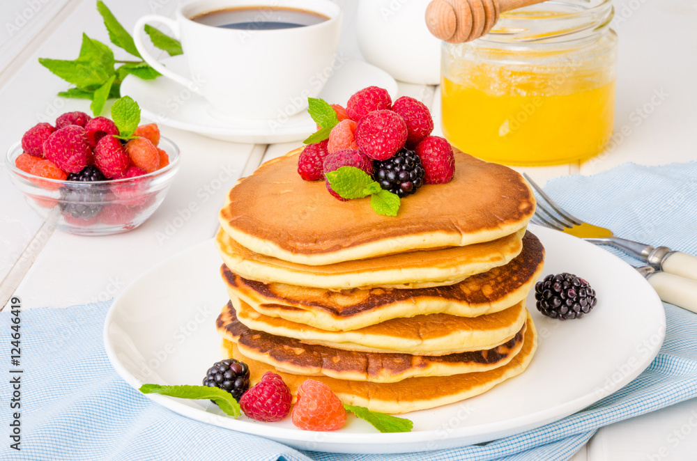 Stack of delicious american pancakes with berries on a white background Stack of delicious american pancakes with berries on a white background