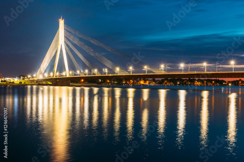 Riga Latvia. Scenic View Of Vansu Cable-Stayed Bridge In Night Illumination Over The Daugava River,