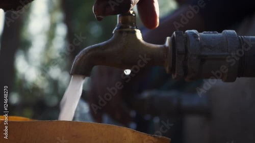 People getting water from a faucet at water point in africa photo