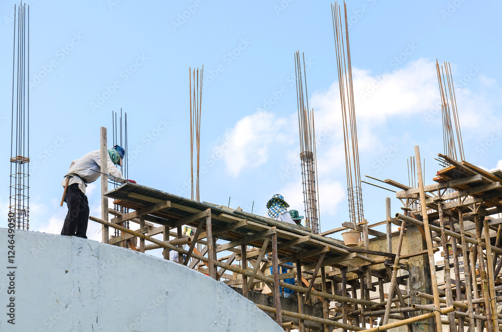 Construction workers collaborating in the installation of cement formwork frames Construction workers collaborating in the installation of cement formwork frames