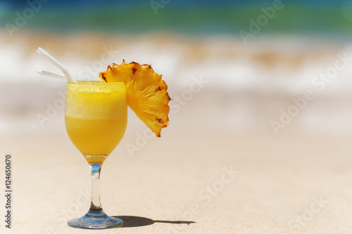friut pineapple cocktail on sandy ocean beach