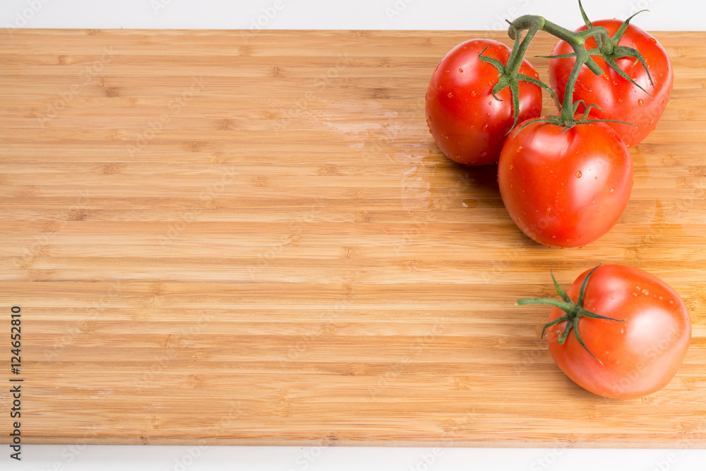 Fresh red tomatoes on a branch. Tomatoes with water drops. Fresh red tomatoes on a branch. Tomatoes with water drops.