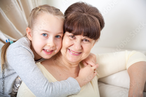 Senior lady with granddaughter happy together in domestic environment
