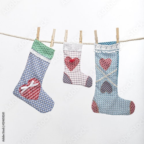 Handmade christmas stoking hanging on a rope over neutral background photo