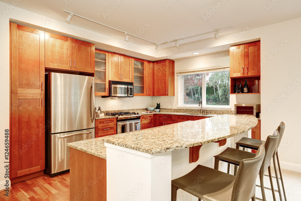 Kitchen interior. Wooden cabinets, granite tops and window view
