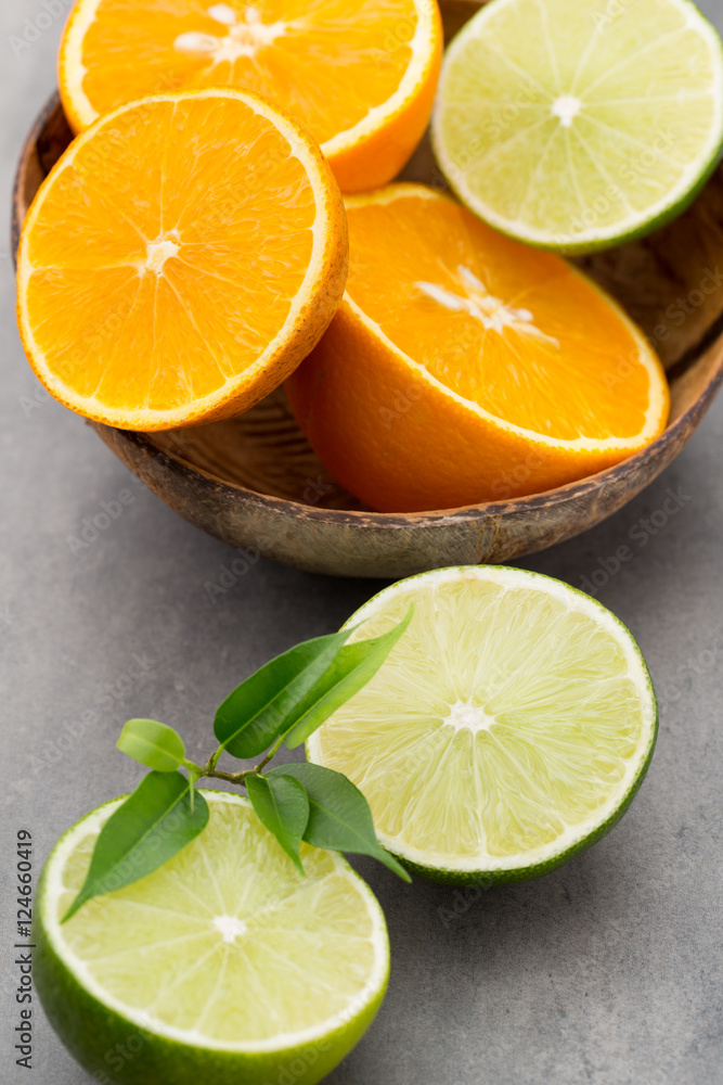 Mixed citrus fruit lemons, orange, kiwi, limes on a gray backgro Mixed citrus fruit lemons, orange, kiwi, limes on a gray backgro
