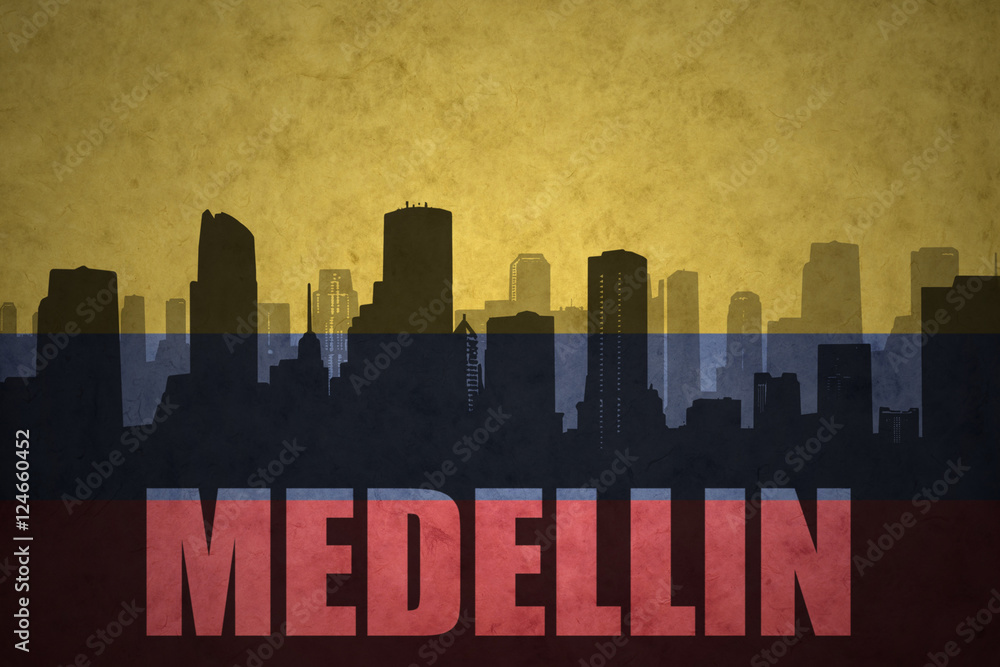 abstract silhouette of the city with text Medellin at the vintage colombian flag