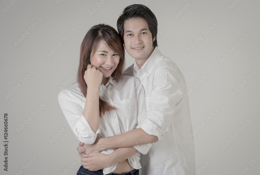 Smiling young couple embracing and standing full length on Cream background,Beautiful loving couple hugging and having fun. Happy Couple in Love Smiling young couple embracing and standing full length on Cream background,Beautiful loving couple hugging and having fun. Happy Couple in Love