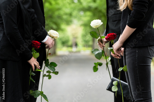 Familie erweist Verstorbenen letzte Ehre und steht im Spalier auf Friedhof bei Beerdigung photo