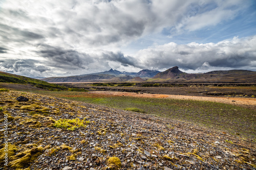View on a huge mountain and small house in Iceland with dramatic sky © grycikua