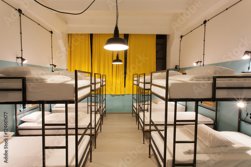 Interior design of a dorm room of tourist hostel with clean beds for twelve people photo