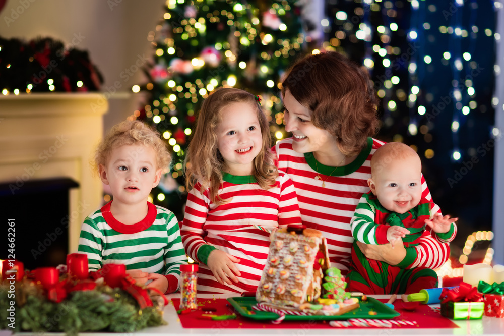Mother and kids making ginger bread house on Christmas Mother and kids making ginger bread house on Christmas