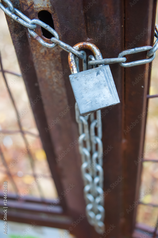 Rusty metal gate closed with padlock and chain Rusty metal gate closed with padlock and chain