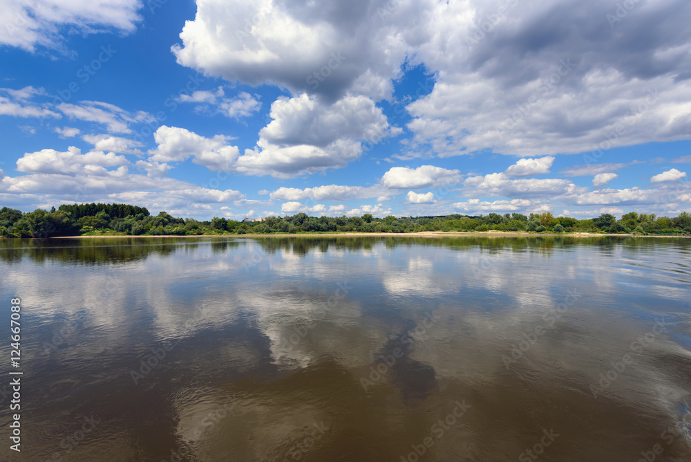 Picturesque clouds on the blue sky over Vistula river in sunny day. Poland, Europe.