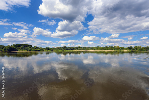 Picturesque clouds on the blue sky over Vistula river in sunny day. Poland, Europe.