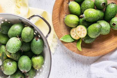 Plenty of feijoa plants on rustic background, in white colander